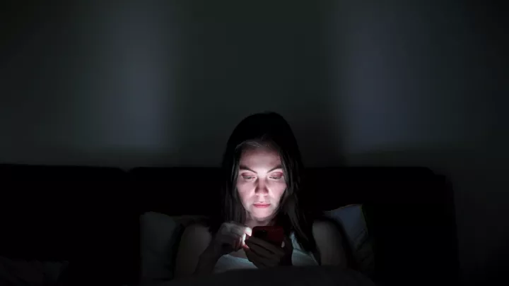 Woman in the dark looking at a screen