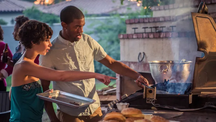 Man and woman standing at grill