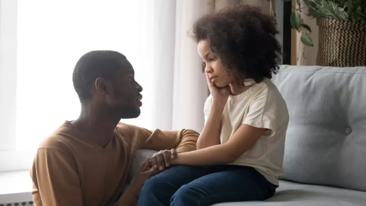 Father kneeling next to his young daughter