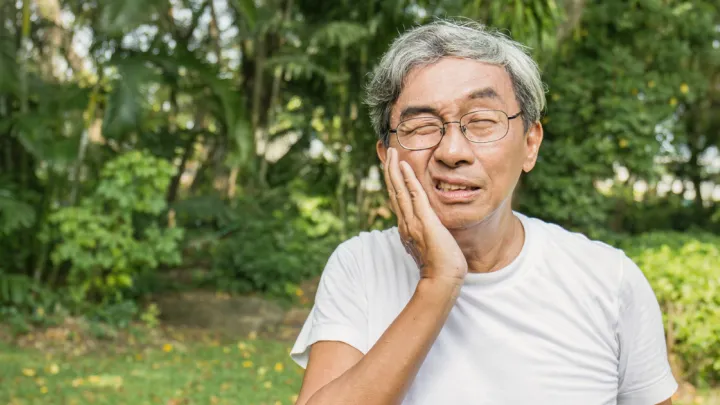 Man holding his mouth in pain