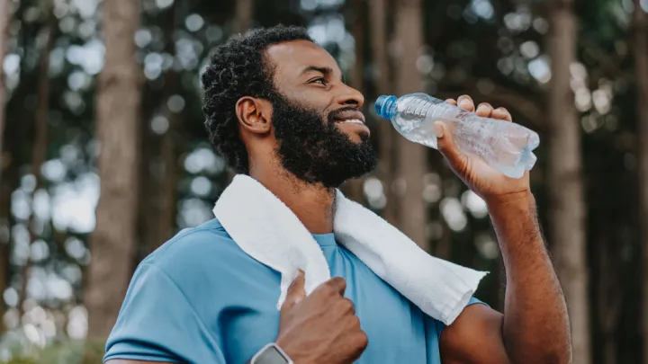 Man drinking from a plastic water bottle