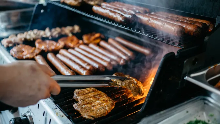 Close up of grilling hotdogs and other meats
