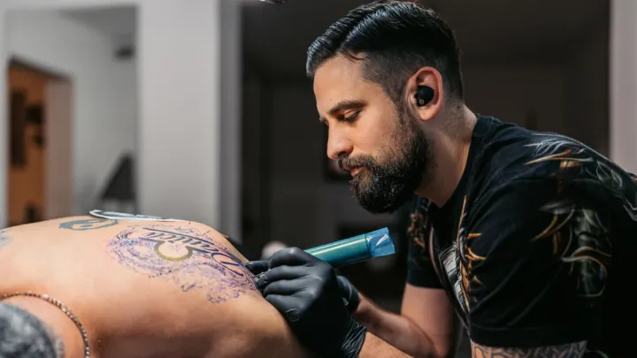 Man tattooing a man's back