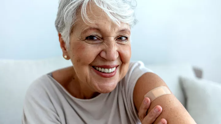 Older woman smiling with bandage on her arm