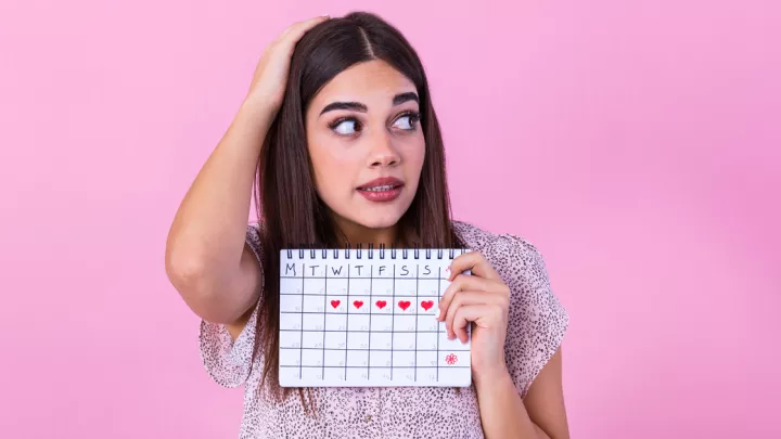 Woman holding calendar looking confused