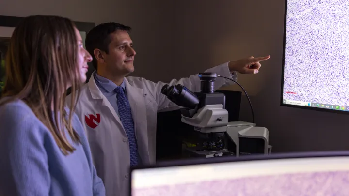 Patient with Corey Georgesen, MD who is pointing at screen
