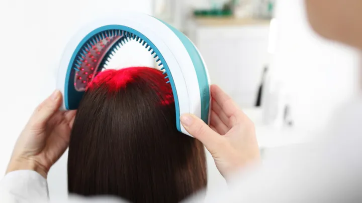 Provider using laser band on woman's head