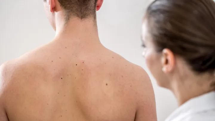 Doctor looking at man's back