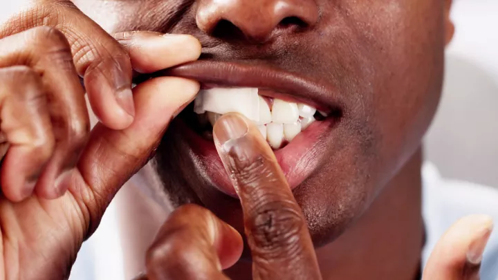 Close up of man putting nicotine pouch in mouth