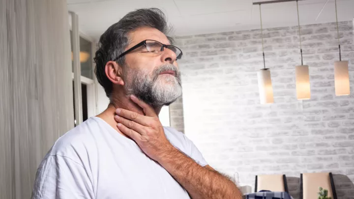 Man holding his throat