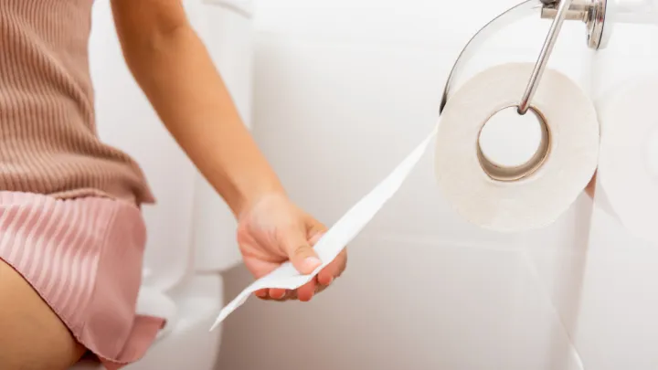 Woman's hand grabbing toilet paper