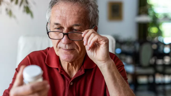 Man looking at pill bottle