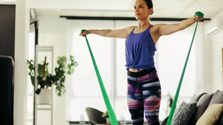 Woman exercising at home with a resistance band