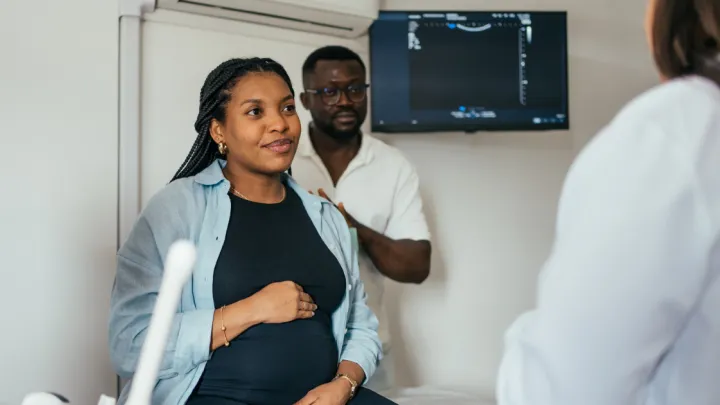 Pregnant woman and husband talking to doctor