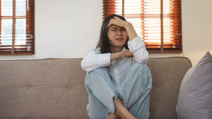 Upset woman sitting on couch
