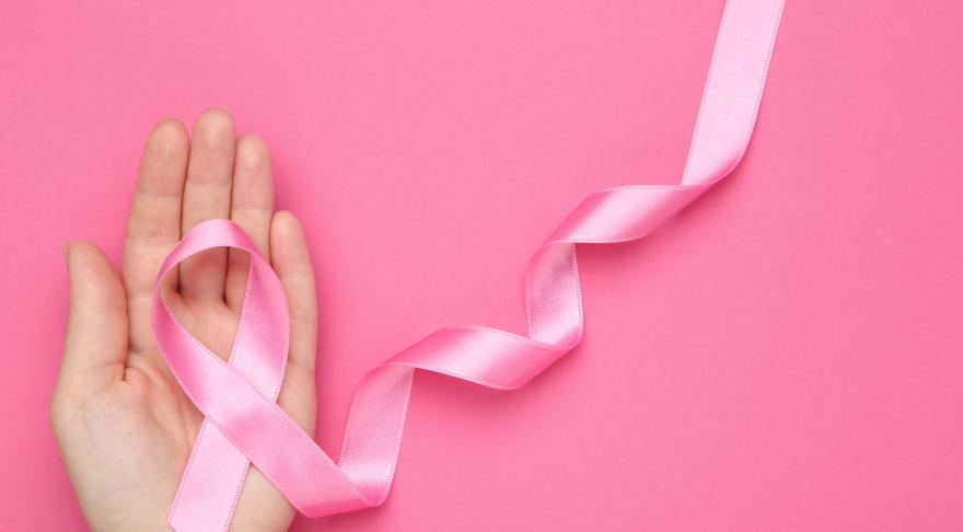 Breast cancer ribbon placed on a palm