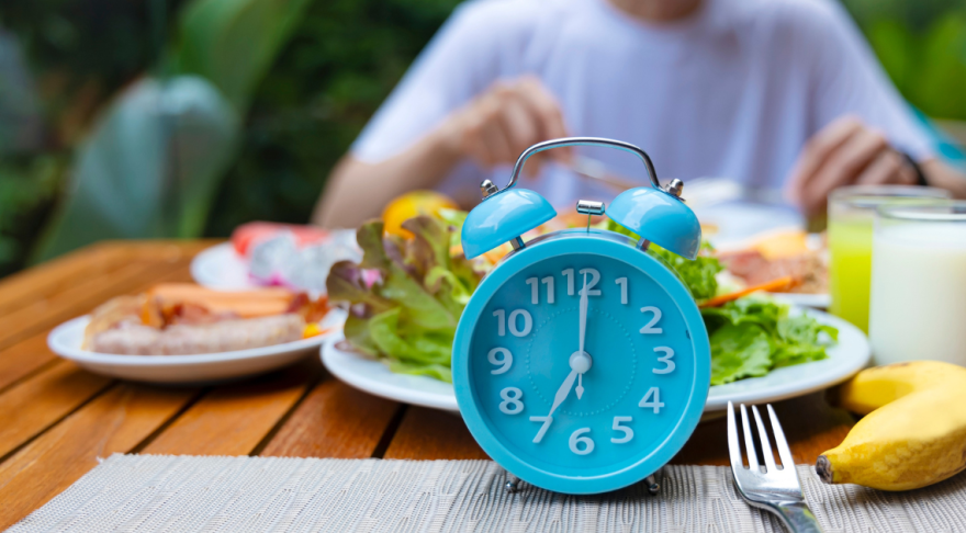 Blue clock in front of man eating meal