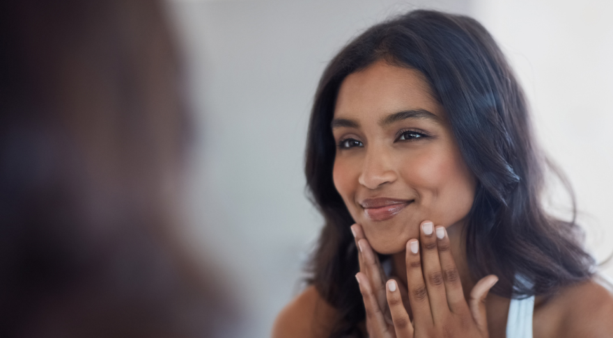 Woman looking at her face in the mirror