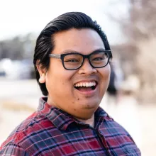 An Asian man excitedly smiling